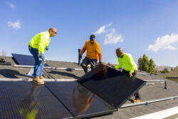 Technicians installing rooftop solar panels to access solar power